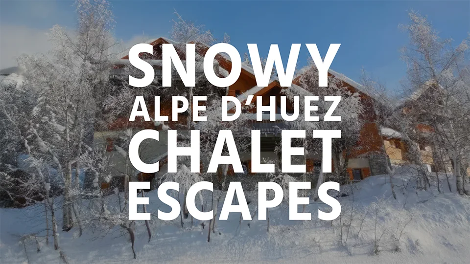 A snow covered ski chalet in Alpe d'Huez surrounded by trees with text overlay 'Snowy Alpe d'Huez Chalet Escapes'