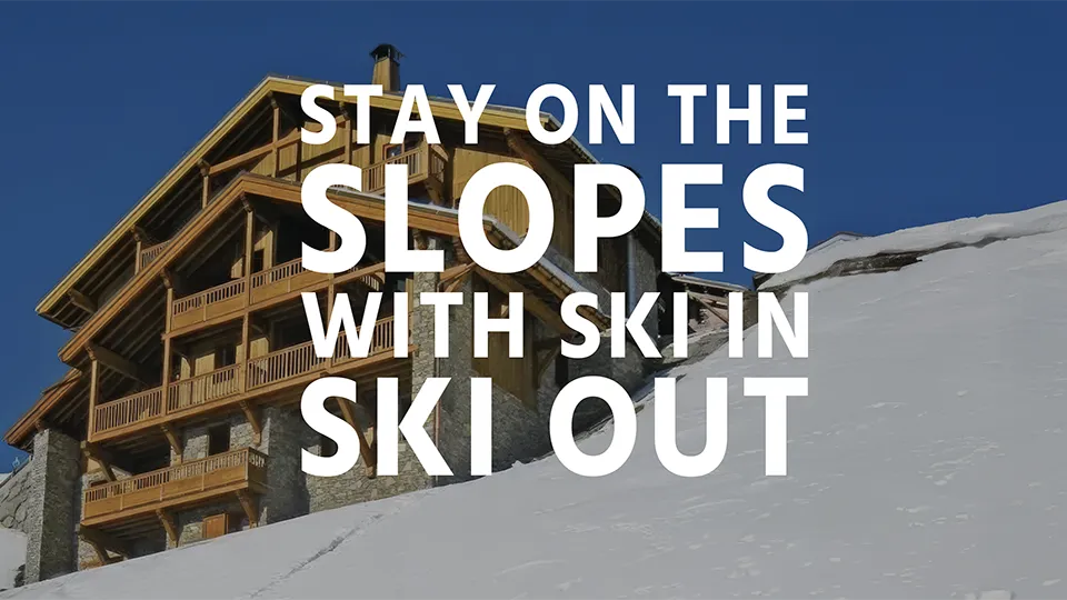 A ski in ski out chalet nested on a snowy mountainside with text overlay "Stay on the slopes with ski in ski out"