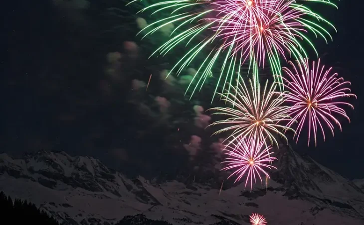 A fireworks display lights up a mountain landscape - New Year Ski Holidays 2026/2027