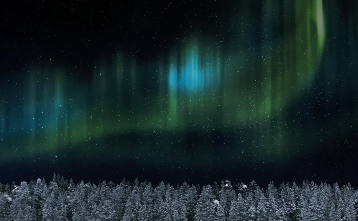The green and blue waves of the Northern Lights above the forests of Saariselka. Ski holidays in Finland and Lapland are more than just skiing.