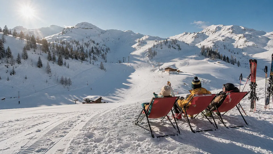 A group of friends looking over sunny slopes on an Easter ski holiday
