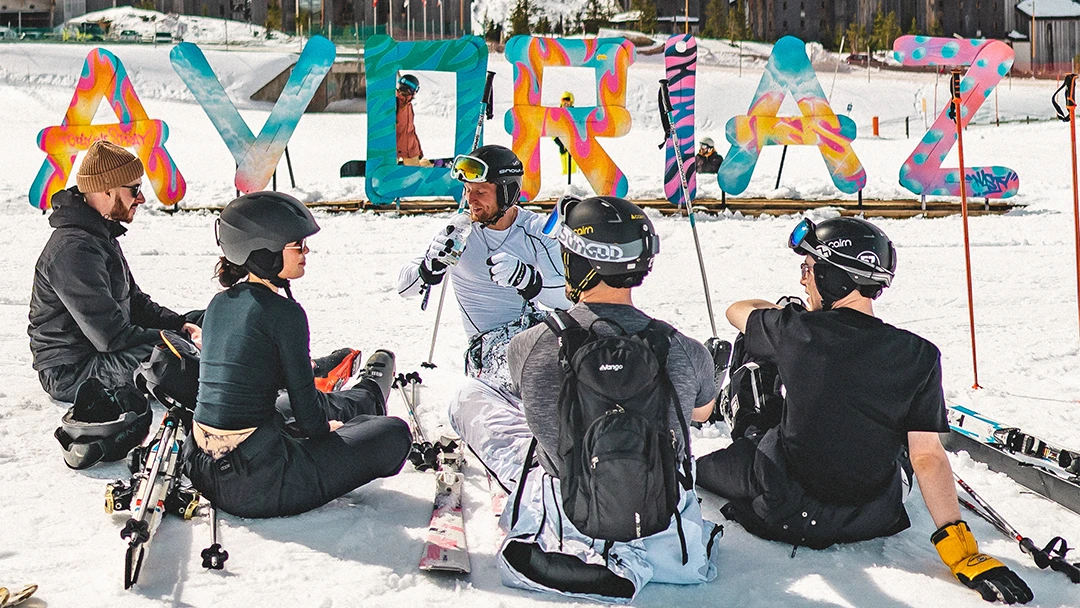 A group of skiers gather around a ski instructor in Avoriaz